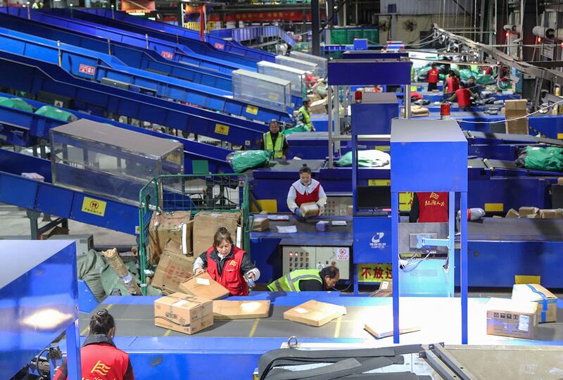 2023年11月12日,湖南省衡阳市一家物流公司的工人正在分拣双十一购物节的包裹。(法新社)