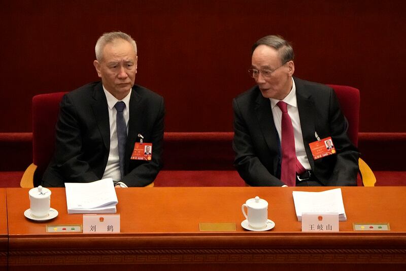 中共中央政治局委员、国务院副总理、金融委主任刘鹤（左）出席2022年3月5日举行的人大会议（美联社）