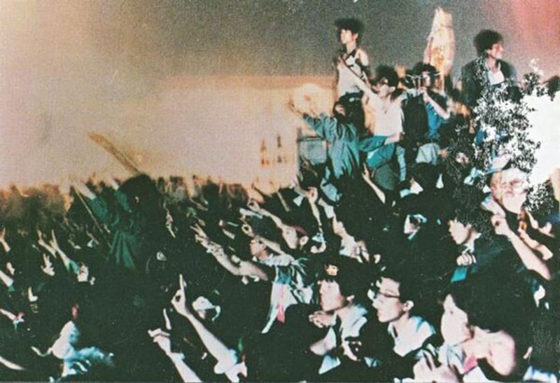 1989年6月4日凌晨四点，大学生们在北京人民英雄纪念碑下高唱国际歌。（六四档案图）