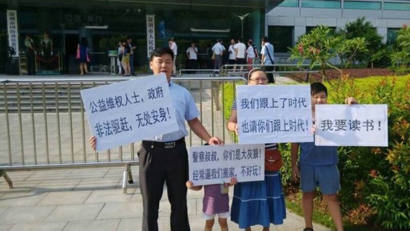 深圳春风劳动争议服务部负责人张治儒（左）被捕前带领家人在街头抗议（Public Domain）