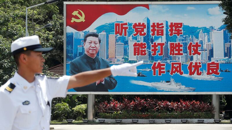 资料图片:一名解放军海军士兵站在中国国家主席习近平的幕布前。 (路透社)