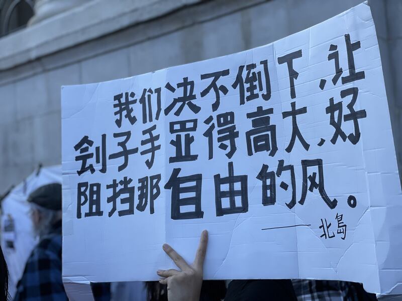 不少中国留学生手持鲜花和自制标语，默默加入集会。(吕熙拍摄)