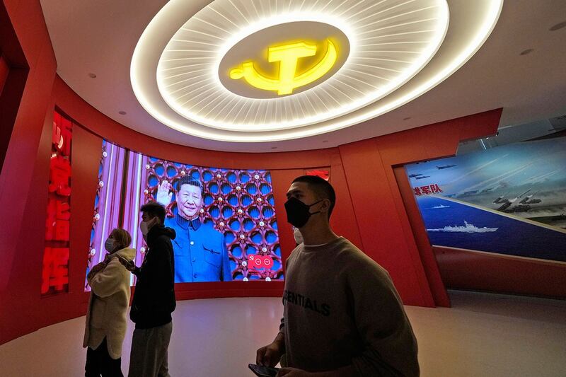 资料图片:北京军事博物馆,参观者站在展示习近平和“听党指挥”标语旁边。(美联社)