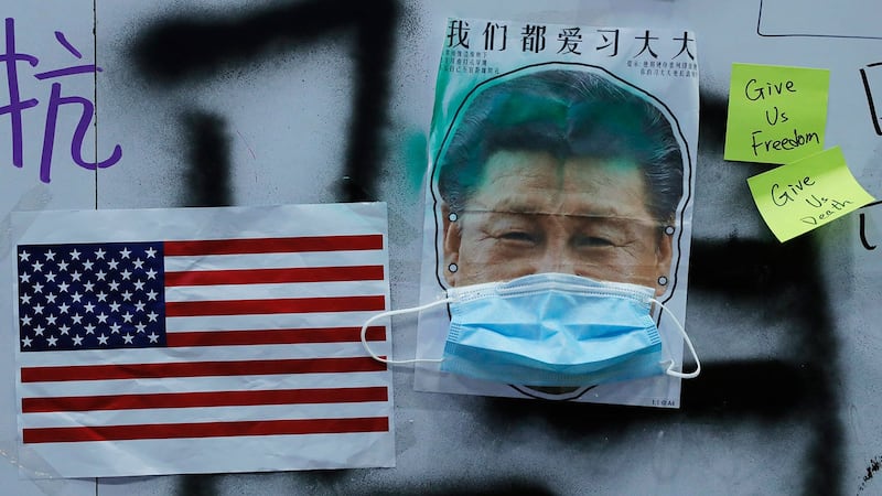 中共内部对如何处理美中经贸摩擦、香港示威以及国内经济下行等问题,出现严重分歧,进而出现权力斗争。图为香港抗议者制作的美国国旗和习近平戴着面具的图片。(资料图/美联社)