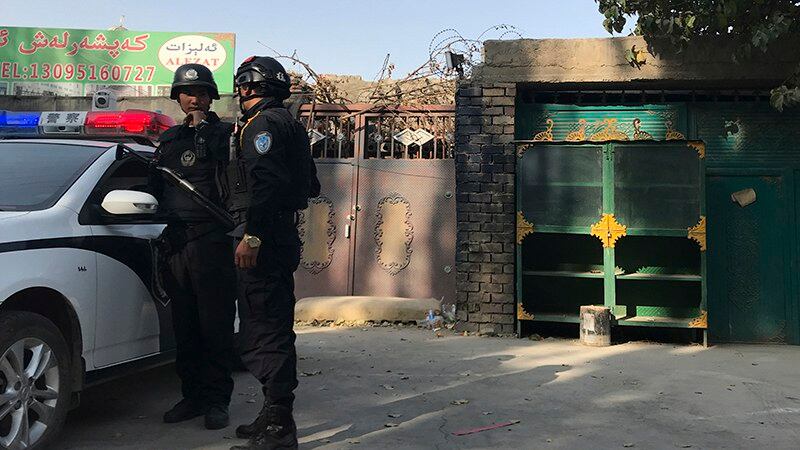 警察在新疆一所再教育营前巡逻(美联社)