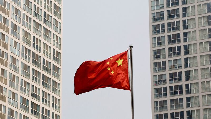 北京的一座高层住宅和办公大楼之间随风飘扬的中国国旗。 (美联社)