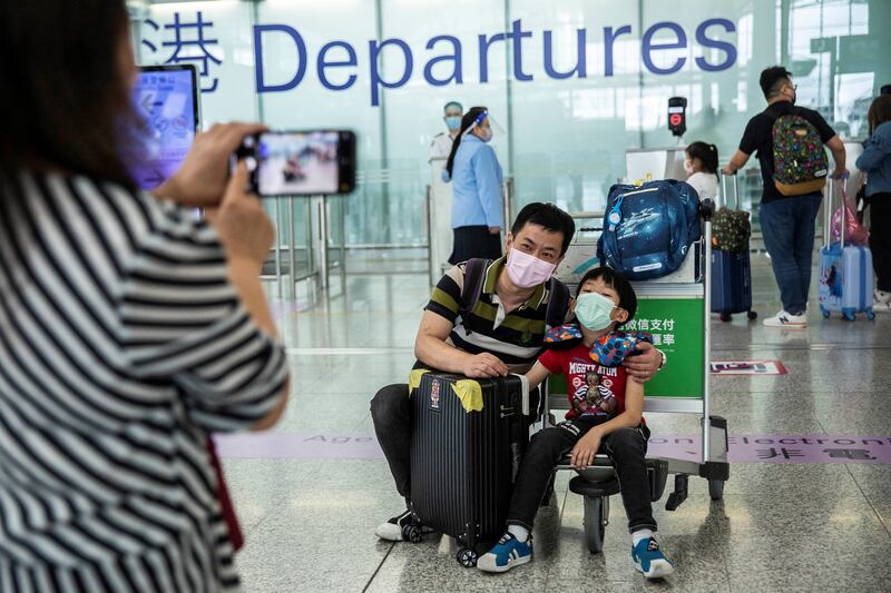 This picture taken on July 19, 2021, shows a family taking a photo at the departure gates of Hong Kong's International Airport before they emigrate to Britain.