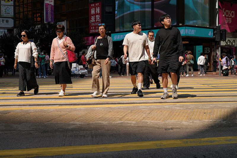 2024年3月20日,香港通过《维护国家安全法案》(也称为《基本法》第 23 条)后,人们走过铜锣湾购物区。(路透社)