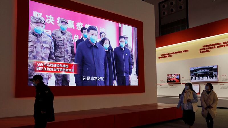 2020 年 12 月 31 日，在武汉会展中心举办的抗击冠状病毒病疫情展览，参观者走近展示习近平的屏幕。 （路透社）