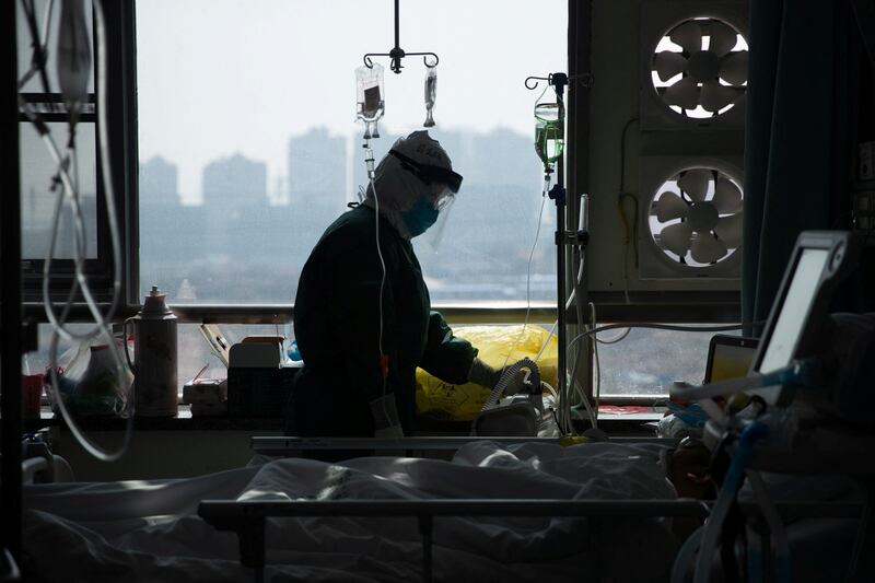 A medical worker in protective suit attends to a patient in an isolated ward of a hospital in Wuhan, the epicenter of the novel coronavirus outbreak, Hubei province, China, Feb. 22, 2020.