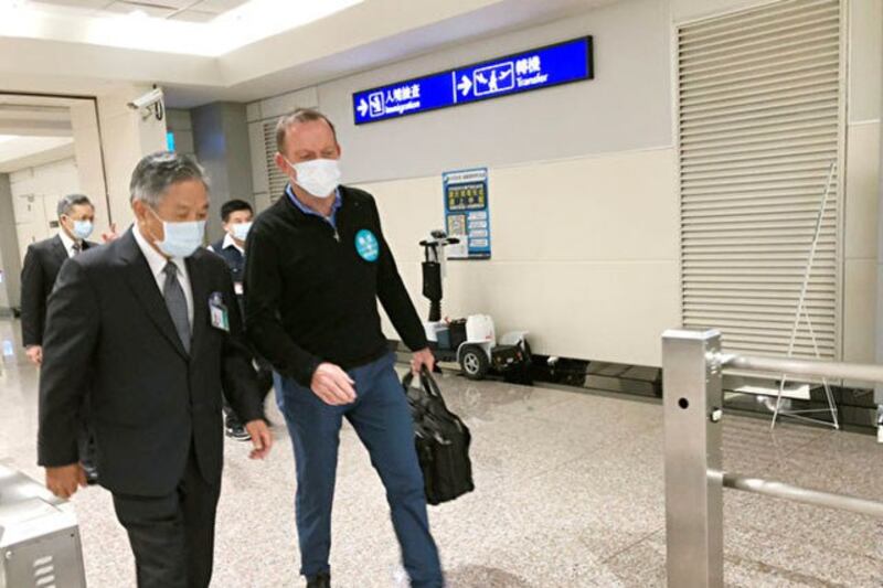 2021年10月5日下午,澳大利亚前总理阿博特(Tony Abbott)(前左)抵达桃园国际机场,随即在外交人员陪同下通关。 (中央社)