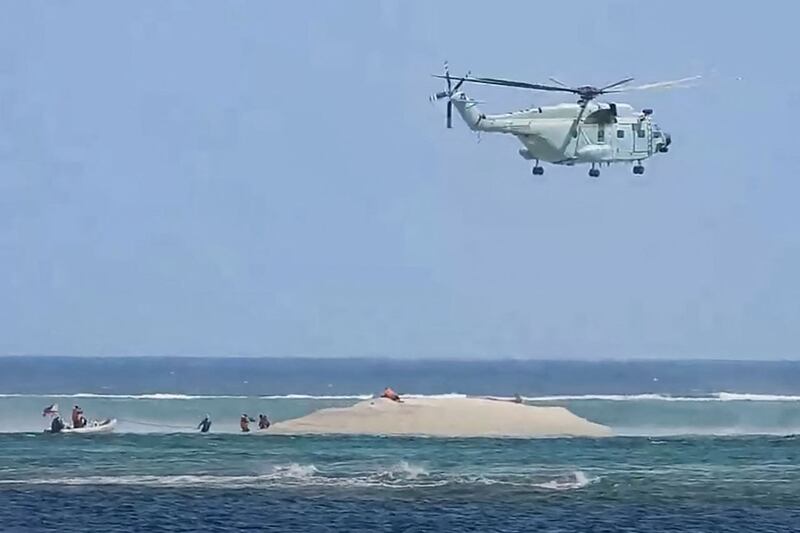 菲律宾渔业和水生资源局 (PCG/BFAR) 拍摄并发布的照片显示,一架中国直升机2024年3月25日在菲律宾科学家考察的南沙群岛中业岛附近的一个珊瑚礁上盘旋。(PCG/BFAR/ Philippine Coast Guard / AFP)