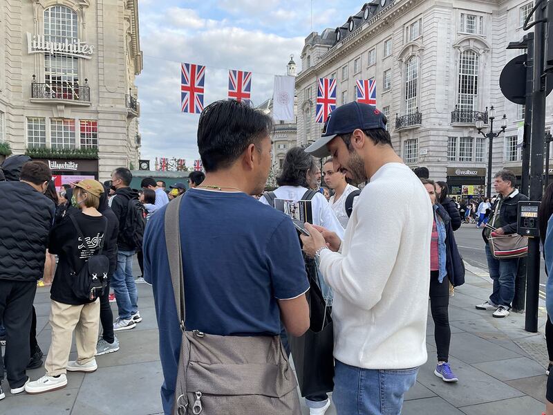 参与集会的港人Anthony努力向途人解释联署行动。 (吕熙摄)