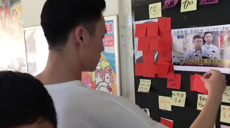 台湾艺术大学陆生，拿港生免费提供的便利贴，恶意将港生、台生留言声援香港的便利贴覆盖。（港生张俊豪提供）