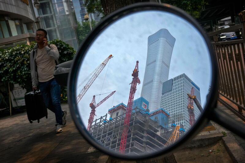 2024年6月5日,北京市中央商务区办公楼附近一辆电动滑板车的后视镜反射出的建筑工地。(美联社)