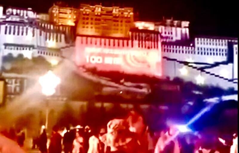 在拉萨布达拉宫脚下观看中共政宣灯光投影的汉人游客 (视频截图)