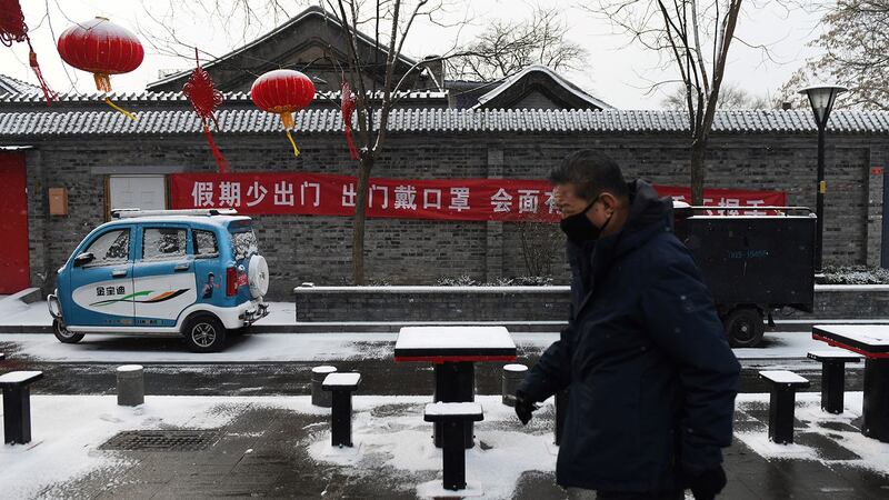 疫情之下,第一个彻底归零的行业挂红灯笼贴春联的余丰里民宿,目前已经大门紧闭。图为2020年2月5日,北京一条小巷挂着横幅标语:假期少出门,出门戴口罩....。(法新社)