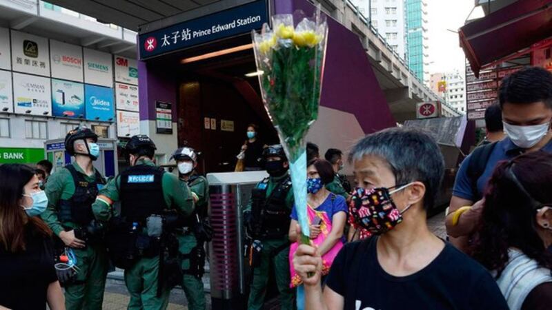 今年8月31日是香港831太子站事件一周年。图为当天地铁太子站外手捧鲜花纪念的一名妇女。(美联社)