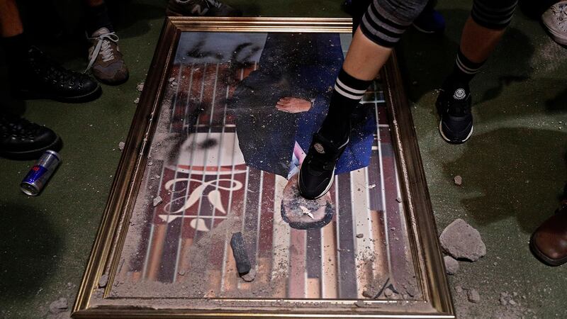 香港反对《逃犯条例》修订示威人士冲进香港立法会大楼拆下立法会领袖画像踩踏。(美联社)