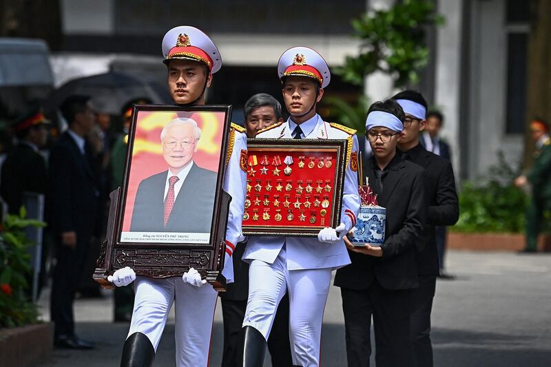 A member of Vietnam's armed forces carries a portrait of the late General Secretary of the Communist Party Nguyen Phu Trong during his funeral in Hanoi on July 26, 2024. (Nhac Ngueyn/Pool via AFP)