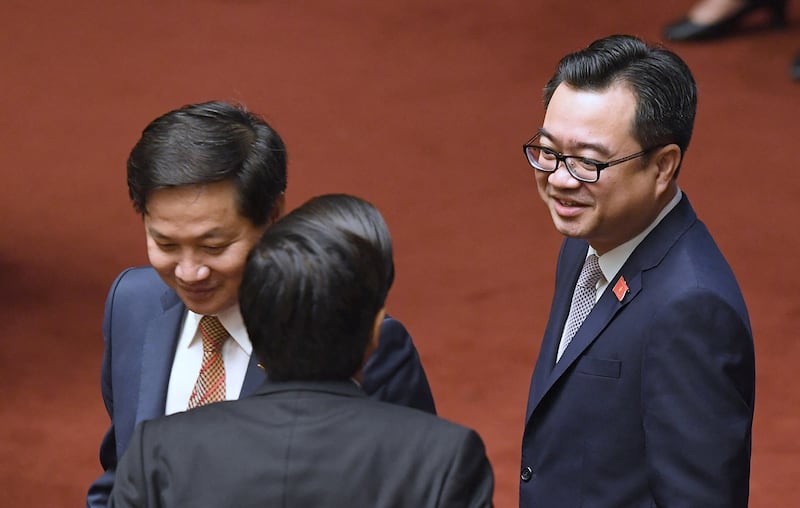 Nguyen Thanh Nghi, right, chats with delegates before the opening of the National Assembly in Hanoi on Oct. 23, 2017.