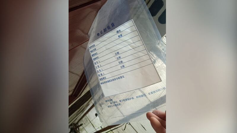 谢文飞的住所大门,贴着一个写有“物证封存”的塑料袋。(志愿者提供/记者乔龙)