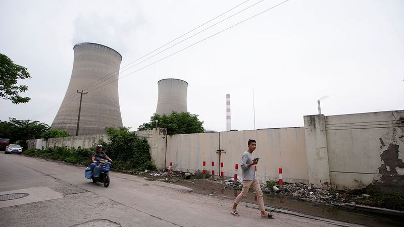 一名男子走过中国上海的一座燃煤电厂。（路透社）