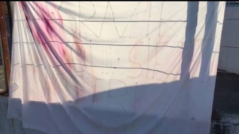 意大利某家医院的外墙挂着布条感谢医护人员，录下影片的神父哭着口述白布写着“你是我们的英雄”。（截自灵医会提供影片）