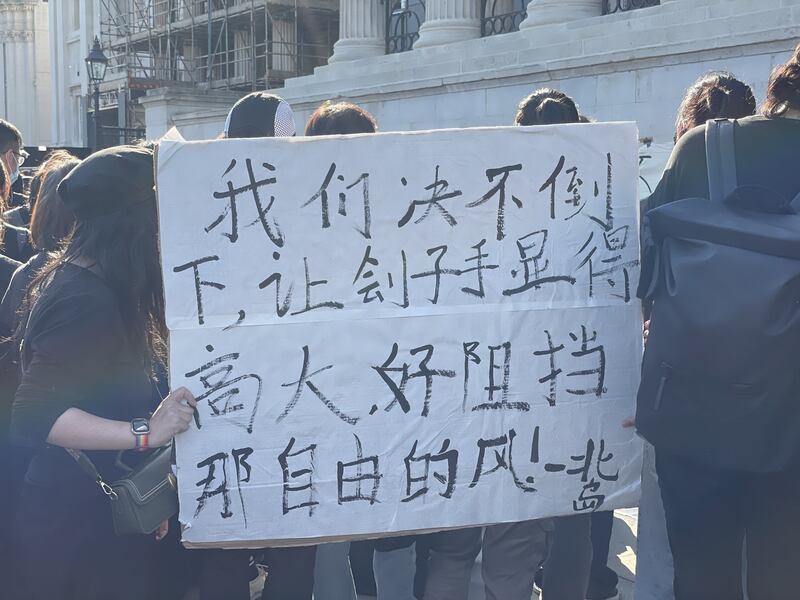 不少中国留学生手持鲜花和自制标语，默默加入集会。(吕熙拍摄)