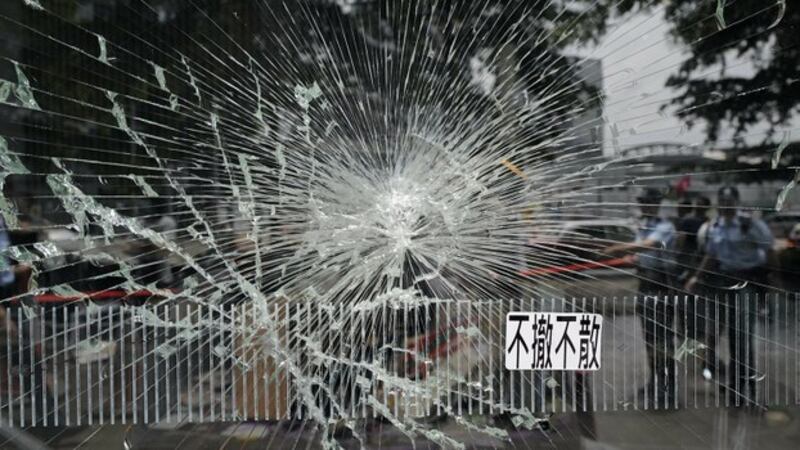 警方在香港立法会大楼破损的一面玻璃窗外执勤(美联社)