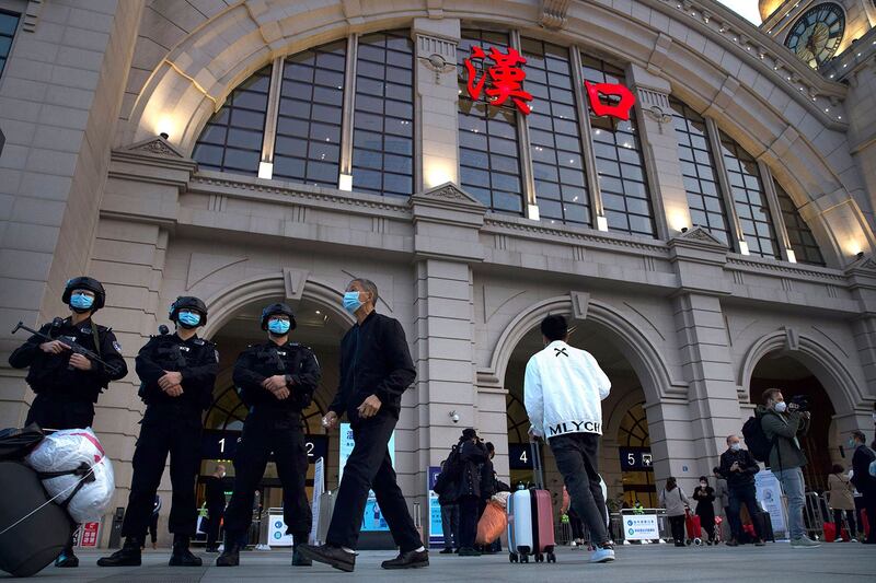 图为,2020年4月8日,在武汉市恢复列车服务之前,戴着口罩的警察在汉口火车站外。(美联社图片)