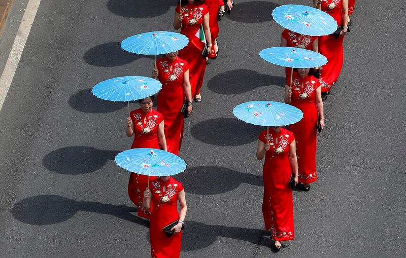 A group of Chinese girls marches in downtown Milan, Italy, May 20, 2017, to support migrants' rights.